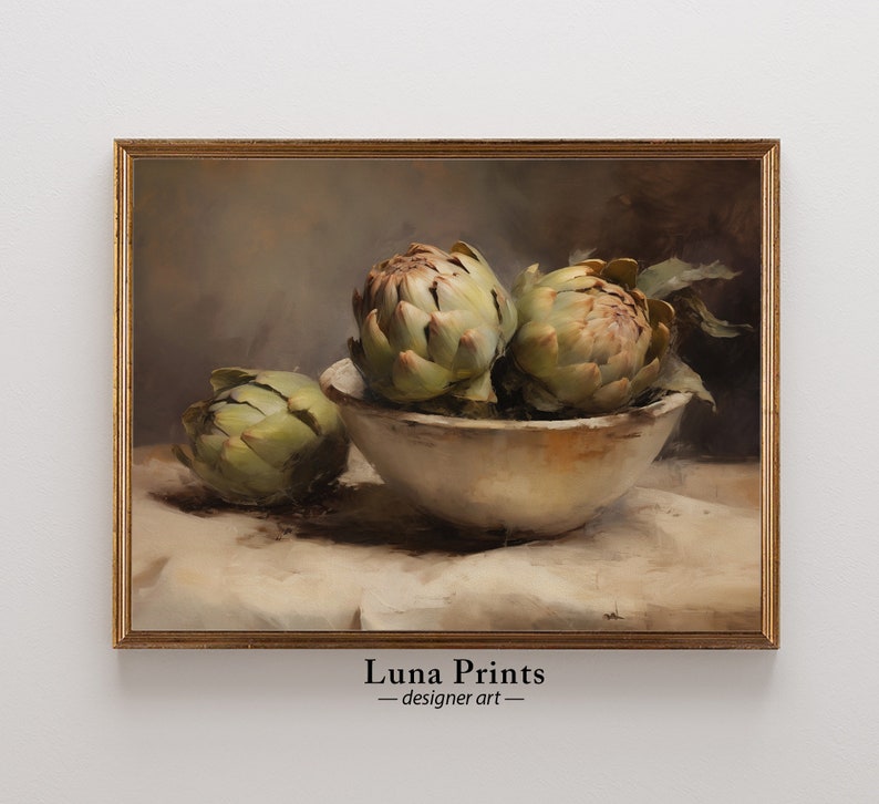 May include: A still life painting of three artichokes in a white bowl on a white tablecloth. The artichokes are green and have a brown hue. The painting is framed in a gold frame.