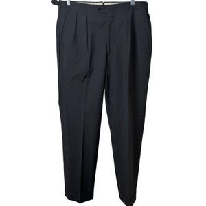 May include: A pair of dark charcoal gray trousers featuring a pleated front, a button closure at the waistband, and side adjusters with metal buckles. These full-length dress pants have a straight leg cut and cuffed hems, presented on a hanger.
