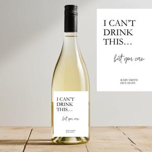 Può includere: Una bottiglia di vino bianco con tappo nero e un'etichetta che recita "I CAN'T DRINK THIS... but you can" con "BABY SMITH DUE DATE" sotto. Una carta abbinata è accanto alla bottiglia.