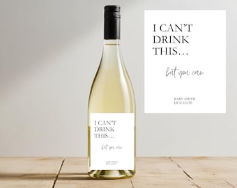 May include: A white wine bottle with a black cap and a label that reads "I CAN'T DRINK THIS... but you can" with "BABY SMITH DUE DATE" below. A matching card is next to the bottle.