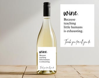 May include: A wine bottle with a black cap and a white label. The label reads "wine. Because teaching little humans is exhausting. Thank you for all you do." A white card with the same text is next to the bottle.