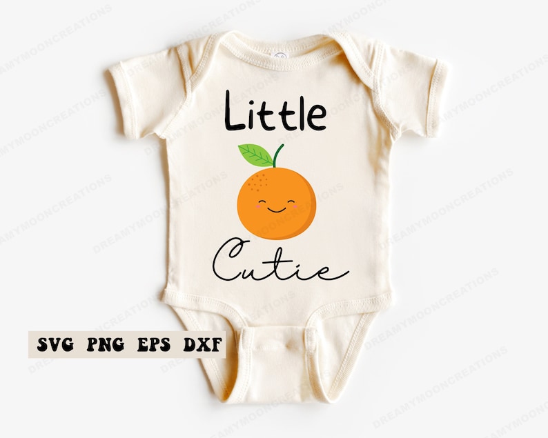 Może przedstawiać: Biały śpioszek z napisem "Little Cutie" i kresk&oacute;wkową pomarańczą z uśmiechającą się buzią.