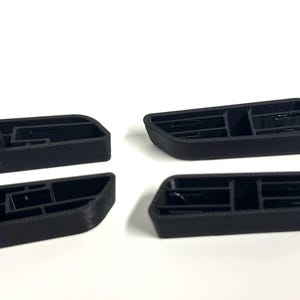 May include: Four black plastic vent covers with a grid pattern. The covers are designed to fit into a car's dashboard or other interior panel.