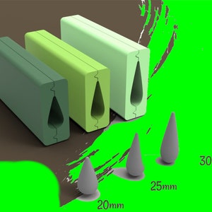 Puede incluir: Tres bloques rectangulares verdes con un recorte en forma de lágrima. Los bloques están dispuestos en una fila del más grande al más pequeño. El bloque más grande es de 30 mm, el bloque del medio es de 25 mm y el bloque más pequeño es de 20 mm.