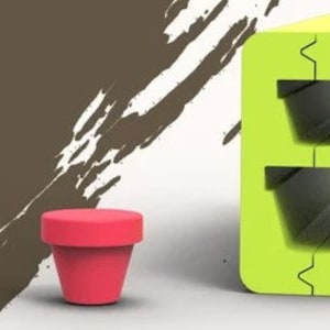 Op de afbeelding: Twee kleine, rode, keramische bloempotten en een grotere, groene, plastic plantenbak met twee lege vakken om te planten. De plantenbak heeft een uniek ontwerp met een zigzagnaad in het midden.