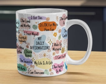 May include: White ceramic mug with a colourful design featuring positive affirmations. The text on the mug includes "My Daily Affirmations", "I Am Loved and Worthy", "I Trust Myself", "I Deserve Respect", "I Am Successful", "My Life Is A Gift", "I Can Overcome", "I Wake Up Motivated", "I Care For Me", "I Am Happy To Be Me", and "It's OK For Me To Have Fun".