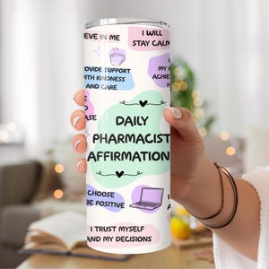 May include: A white tumbler with a colorful design featuring affirmations for pharmacists. The text includes "Daily Pharmacist Affirmation", "I Will Stay Calm", "Provide Support With Kindness and Care", "Choose to Be Positive", and "I Trust Myself and My Decisions".