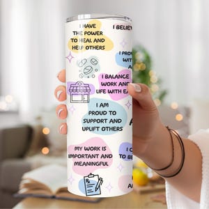 May include: White tumbler with colorful circles and text that reads "I have the power to heal and help others", "I balance work and life with ease", "I am proud to support and uplift others", "My work is important and meaningful", "I believe I provide with a", "I choose to be", "I am", "I am a".