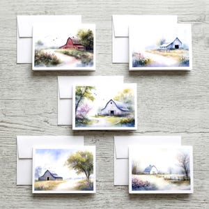May include: Set of five blank greeting cards with watercolor paintings of barns in a rural landscape. Each card features a different barn scene with a white envelope. The cards are square and feature soft colors.