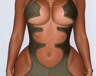 May include: An olive green romper featuring a halter neckline and a lace-up front design with thin strings. The garment includes large cut-out sections along the torso and sides, extending down to short-length bottoms with a fitted silhouette.
