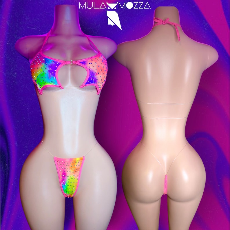 May include: A two-piece lingerie set with a rainbow tie-dye pattern and pink straps. The set is adorned with rhinestones and features a keyhole cutout in the front.