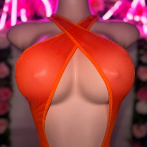 Op de afbeelding: Een feloranje mouwloze bodysuit gemaakt van doorschijnende mesh-stof. Het kledingstuk heeft een hoge halslijn met een kriskras bandontwerp dat een diep uitgesneden effect cre&euml;ert over de borst en romp, afgewerkt met bijpassende oranje randen.