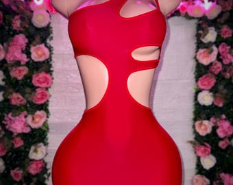Peut inclure: Une robe rouge courte à une épaule avec des découpes sur les côtés et le corsage. La robe est faite d'un tissu extensible et moulant.