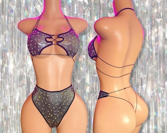 Può includere: Un set di lingerie argento e nero con un top halter e un fondo a vita alta. Il top ha un design incrociato sul davanti e il fondo ha una gamba a taglio alto.