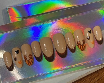 May include: Set of seven false nails with a brown tip and a cartoon character design. The characters are Mickey Mouse and a bee.