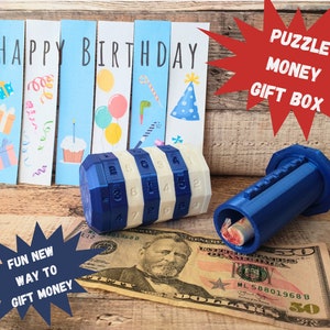 May include: A blue puzzle money gift box with a combination lock. The box is open and a $50 bill is visible inside. The box is sitting on a wooden surface with a birthday card and a fun new way to gift money sign.
