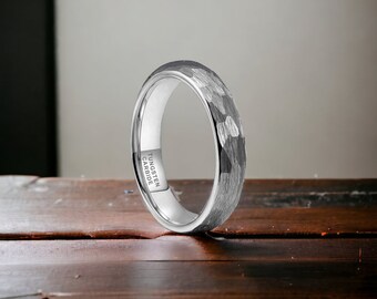 Peut inclure: Une bague en carbure de tungstène argentée avec une finition martelée. La bague est gravée avec "TUNGSTEN CARBIDE".