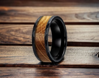 May include: A black and brown ring with a wood inlay and a textured band.