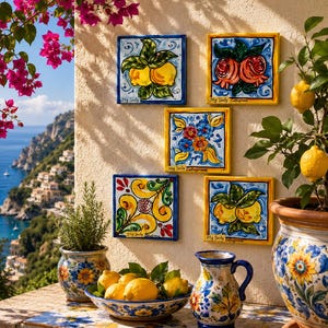 Op de afbeelding: Vijf vierkante keramische tegels met handgeschilderde botanische en florale motieven, waaronder citroenen en granaatappels, met de tekst My Sicily Caltagirone. De tegels hangen aan een muur naast een keramische kan en een schaal met citroenen.
