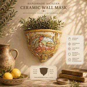 Può includere: Una maschera da parete in ceramica siciliana fatta a mano con finitura antichizzato e un rilievo centrale di una figura alata. L'oggetto misura 31 cm di larghezza, 26 cm di altezza e ha un'apertura superiore di 9 cm, come indicato.
