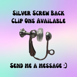 May include: Silver screw back clip on earring with a clear plastic backing. The text "SILVER SCREW BACK CLIP ONS AVAILABLE" and "SEND ME A MESSAGE :)" is visible in the image.
