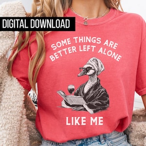 May include: A red t-shirt with the text "SOME THINGS ARE BETTER LEFT ALONE LIKE ME." The shirt features a graphic of a duck wearing glasses, a headscarf, and a robe, reading a book and holding a glass of wine. The words "DIGITAL DOWNLOAD" are in a black rectangle.