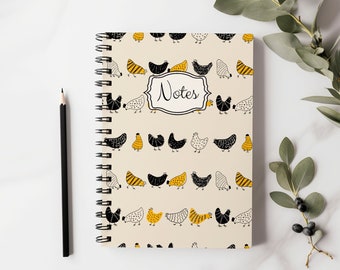 May include: A spiral bound notebook with a cream cover featuring a repeating pattern of black and yellow chickens. The notebook has the word "Notes" printed in black on a white rectangle.
