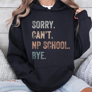 May include: A black hoodie with a vintage-style graphic that reads "Sorry. Can't. NP School. Bye."