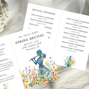 May include: A white recital program with the text "Spring Recital" and event details. The program features a colorful illustration of a person playing a flute amidst wildflowers. The program is tri-fold.