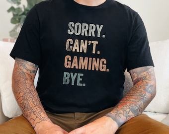 May include: A black t-shirt with a vintage-style graphic that reads "SORRY. CAN'T. GAMING. BYE."