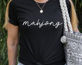 May include: A black t-shirt with the word "mahjong" written in white cursive script.