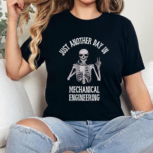 May include: Black t-shirt with a white skeleton graphic and the text "Just another day in mechanical engineering".