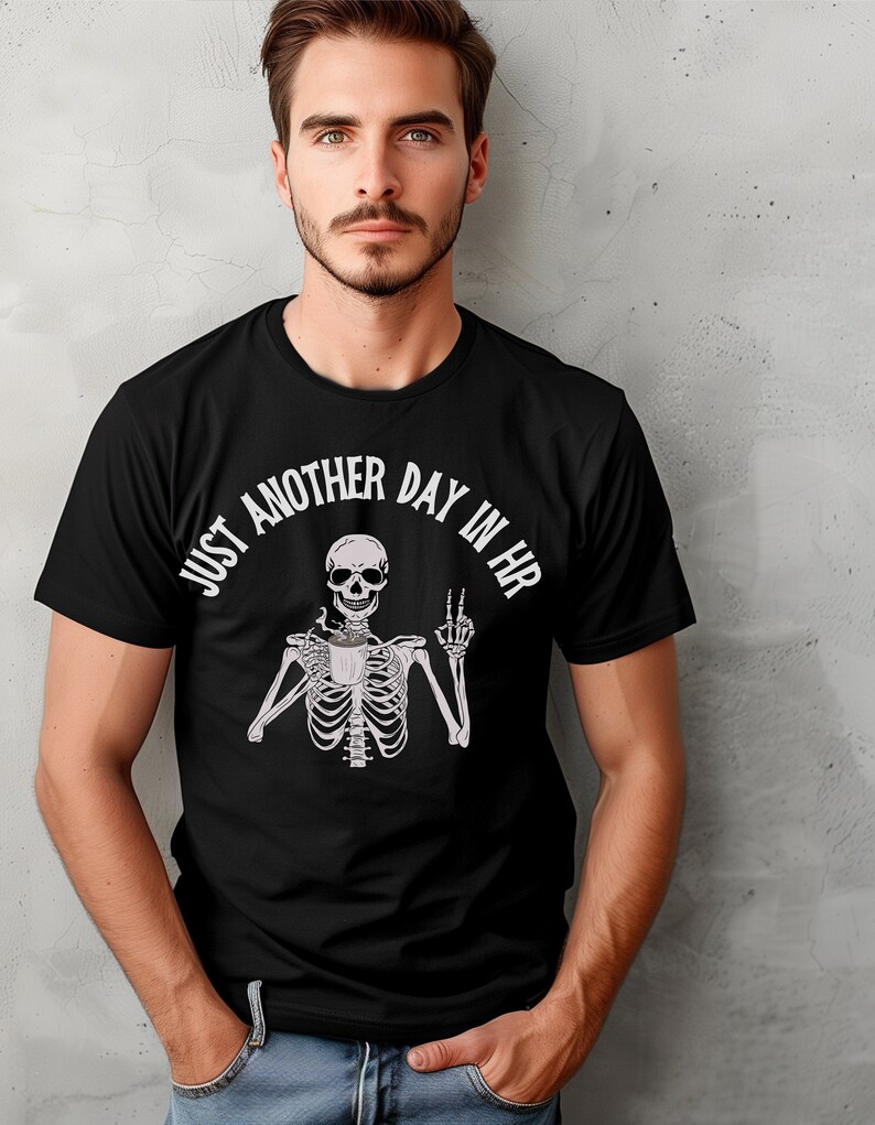 May include: Black t-shirt with a white skeleton holding a coffee cup and making a peace sign. The text "Just another day in HR" is written in a circle around the skeleton.