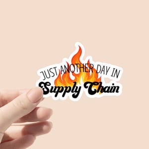 Puede incluir: Una pegatina blanca con un diseño de llama naranja y negra. El texto "Just another day in Supply Chain" está escrito en negro en la pegatina.
