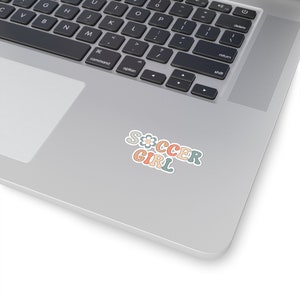 May include: A sticker with the words "Soccer Girl" in colorful, retro-style lettering. A small flower is included in the "S".