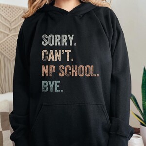 May include: Black hooded sweatshirt with the text "SORRY. CAN'T. NP SCHOOL. BYE." in a vintage style font.