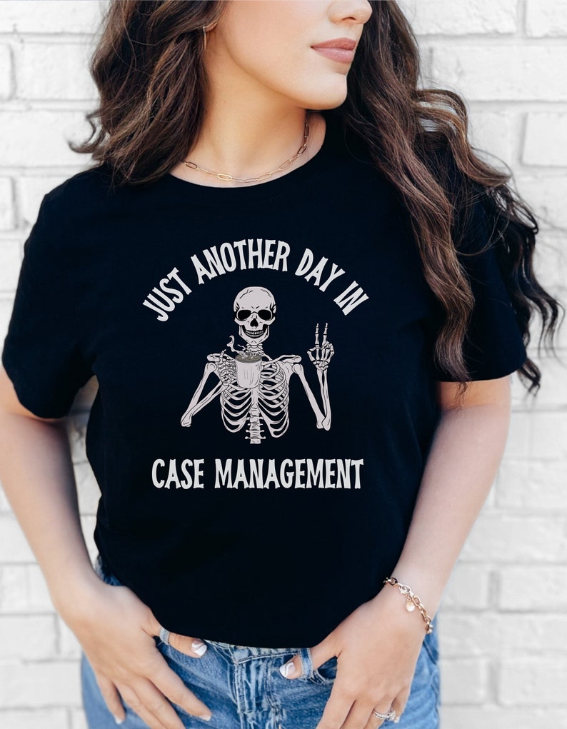 May include: Black t-shirt with a skeleton holding a coffee cup and the text "Just another day in case management".