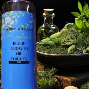 May include: A clear glass bottle of herbal beard growth oil with a blue label. The label reads "2 Tribes on Earth Herbal Beard Growth Oil For Men 8oz." The image also shows herbs, spices, and other ingredients.