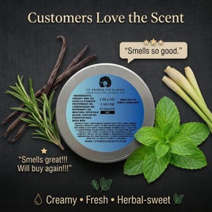 May include: A round tin of 12 Tribes on Earth Creamy Emu Oil Pomade with a blue label listing ingredients like emu oil, vanilla, peppermint, and lemongrass. It is surrounded by vanilla beans, rosemary sprigs, and mint leaves on a black background.