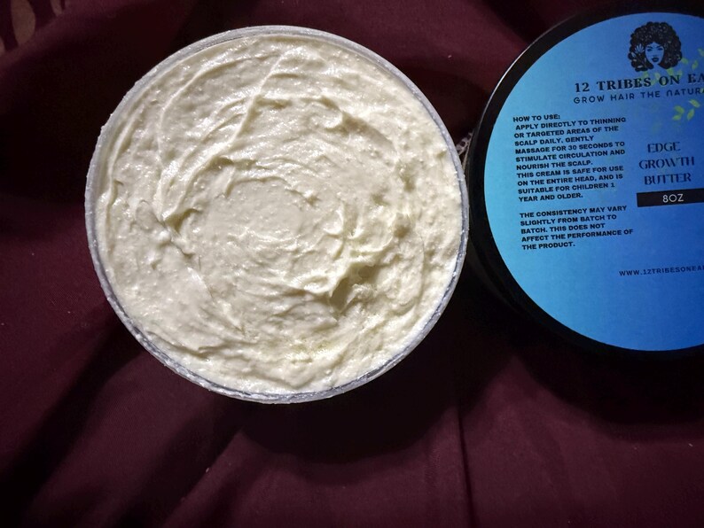 Puede incluir: Un tarro de Edge Growth Butter, 227g, con tapa azul claro y crema blanca. La tapa tiene el texto "12 Tribes On Earth" e instrucciones. La crema tiene una apariencia espesa y texturizada.