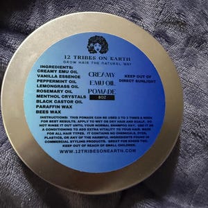 May include: A round metal tin of 12 Tribes on Earth Creamy Emu Oil Pomade. The blue label features the brand name, ingredients list including emu oil, vanilla, peppermint, lemongrass, rosemary, menthol, castor oil, paraffin, and beeswax, plus 8oz net weight.