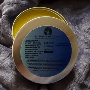 May include: A round metal tin of 12 Tribes on Earth Creamy Emu Oil Pomade. The blue label features the brand name, ingredients including emu oil, peppermint, lemongrass, rosemary, and beeswax, plus instructions and the 8 oz weight specification.