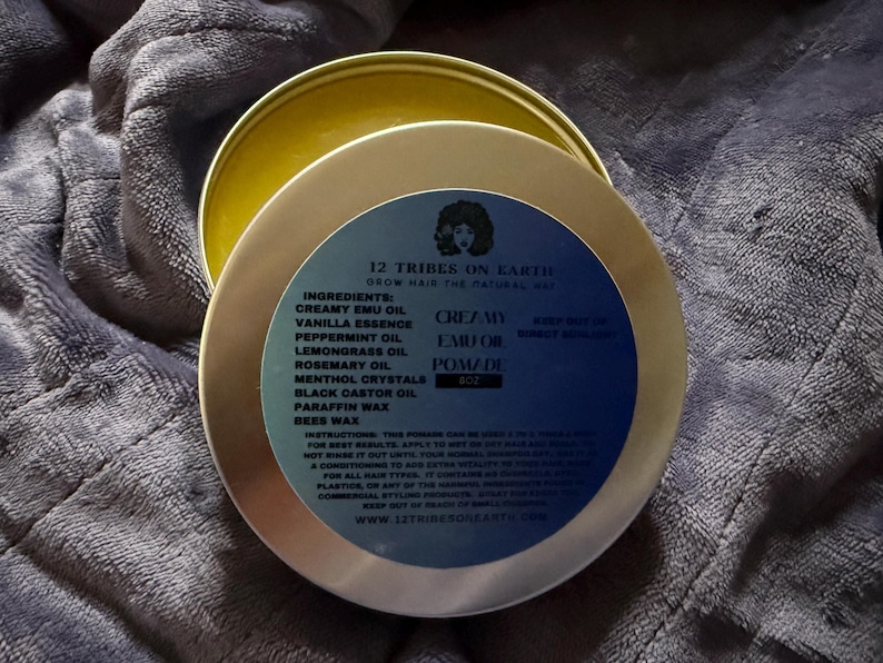 May include: A round metal tin of 12 Tribes on Earth Creamy Emu Oil Pomade. The blue label features the brand name, ingredients including emu oil, peppermint, lemongrass, rosemary, and beeswax, plus instructions and the 8 oz weight specification.