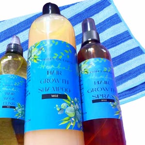 Pode incluir: Três garrafas de produtos para o cuidado do cabelo sobre uma toalha de listras azuis e brancas. As garrafas são etiquetadas com "Hair Growth Shampoo 16oz" e "Hair Growth Spray 8oz".