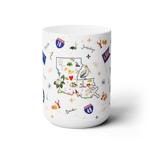 May include: White ceramic mug with a colorful illustration of the state of Louisiana. The illustration includes iconic landmarks, food, and symbols, such as the fleur-de-lis, a pelican, and a crawfish. The text "Jambalaya" and "Boudin" are also included in the design.