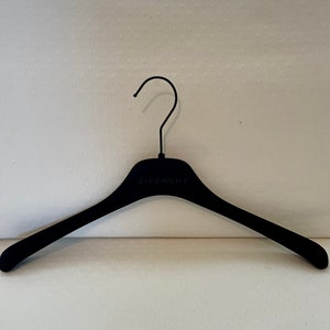 May include: A black velvet hanger with the word "GIVENCHY" printed on the top.