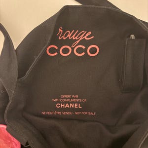 May include: Black tote bag with the words "rouge COCO" in pink script. Below, the text reads "OFFERT PAR WITH COMPLIMENTS OF CHANEL NE PEUT &Ecirc;TRE VENDU - NOT FOR SALE."