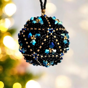 Peut inclure: Une boule de Noël noire en perles avec des accents bleus et dorés. La boule est ronde et présente un motif géométrique.