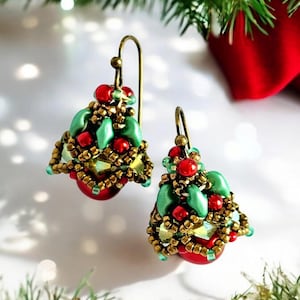 Könnte beinhalten: Ein Paar Ohrringe in Weihnachtsbaumform mit roten, grünen und goldenen Perlen. Die Ohrringe sind mit einer Drahtschlaufe und einem Hakenverschluss gefertigt.