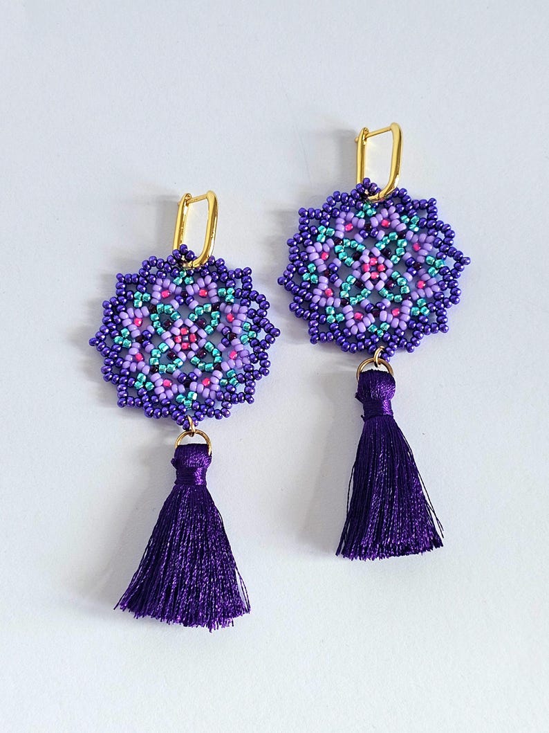 May include: Purple and teal beaded earrings with a gold hook and a purple tassel.
